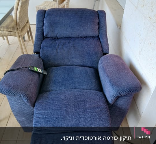 כורסה מרופדת בצבע כחול עם שלט על משענת היד